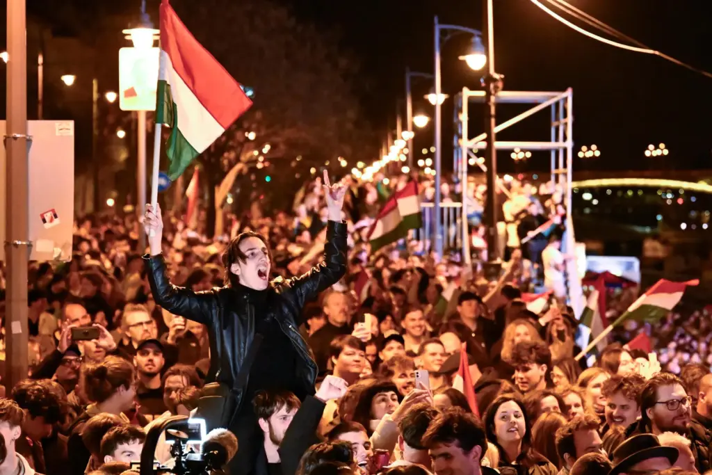 A man waves a Hungarian flag as he celebrates in...