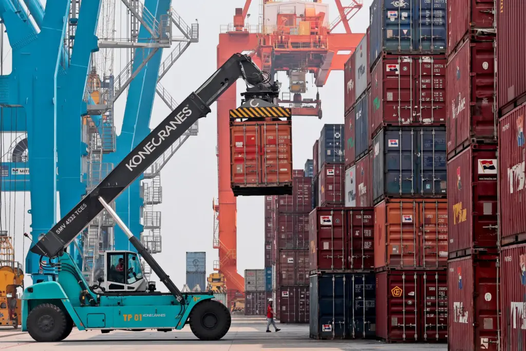 A stacker organizes containers at the terminal of Indonesia Port Corporations.