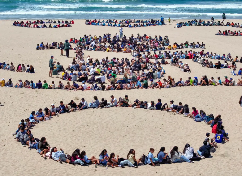 Over 1,000 kids form a giant artwork in the sand...