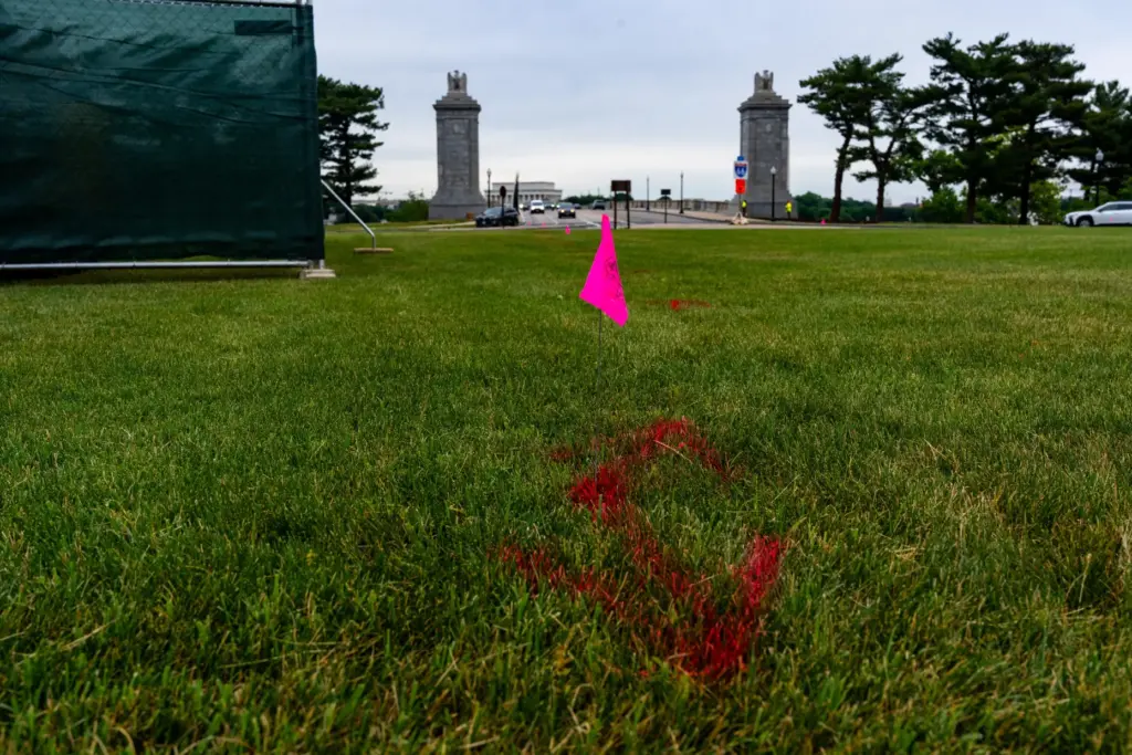 Flags are placed as workers survey the Memorial Circle, where...