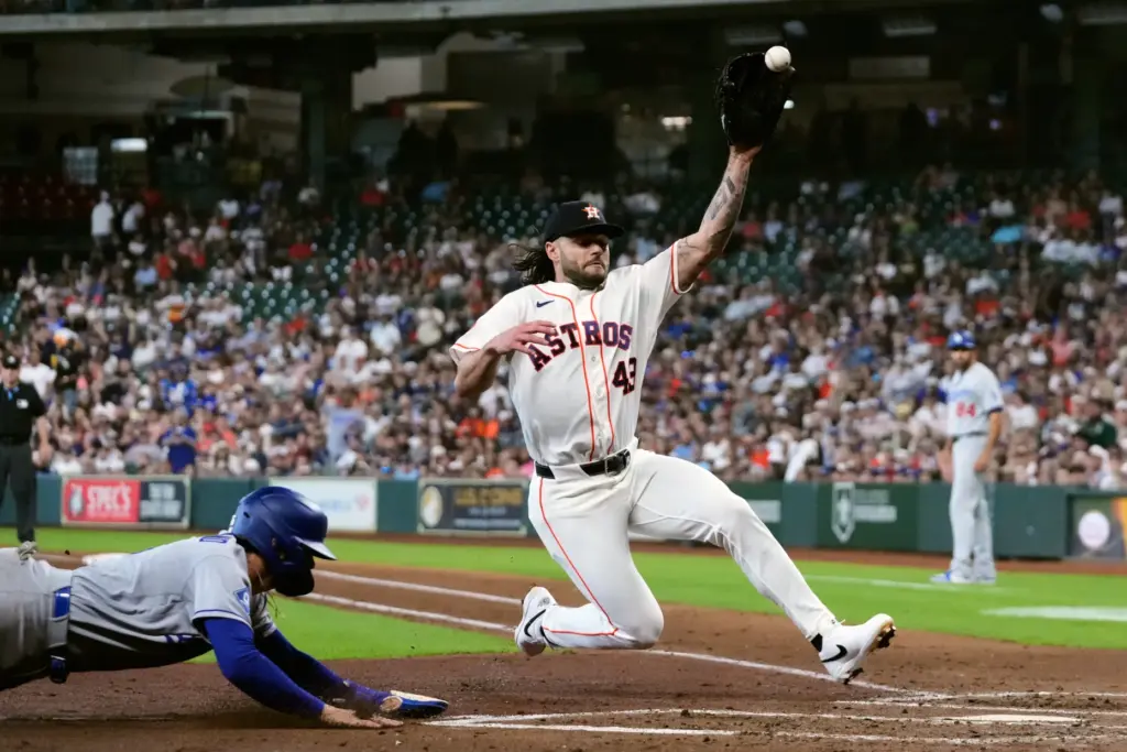The Dodgers’ Alex Freeland, left, scores ahead of a throw...