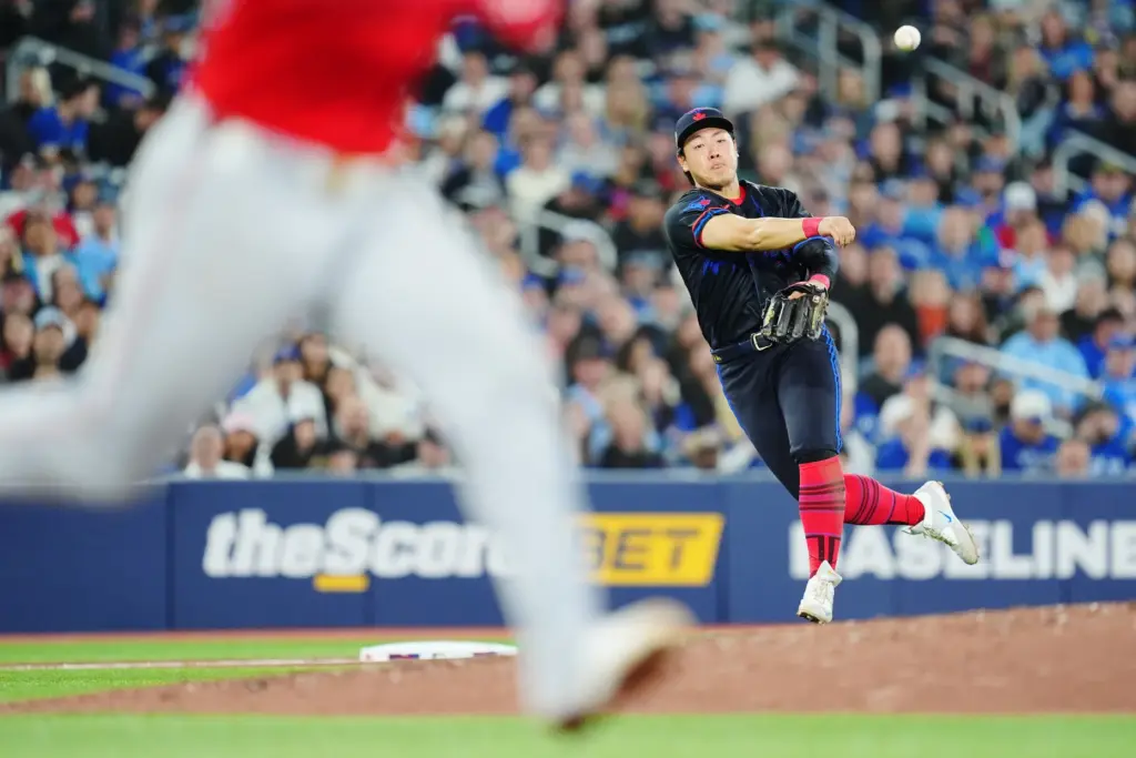 Toronto Blue Jays third baseman Kazuma Okamoto throws to first...