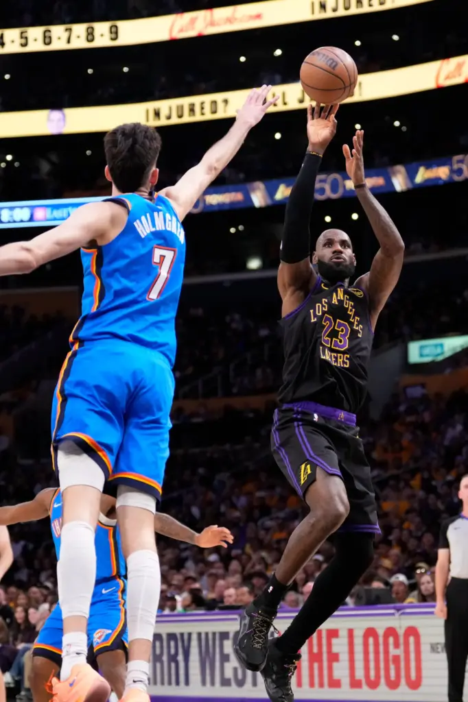 Lakers star LeBron James, right, shoots as Oklahoma City Thunder...
