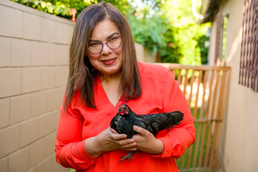 Silvia Salazar holds their pet chicken, Pearl, in the backyard...