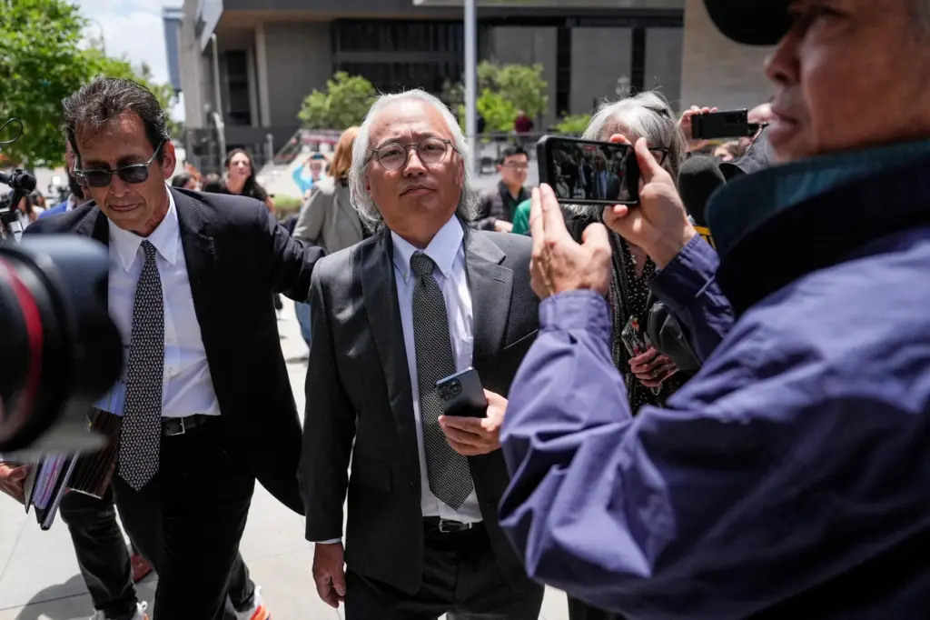 Kenneth Iwamasa, center, one of five people who pleaded guilty...