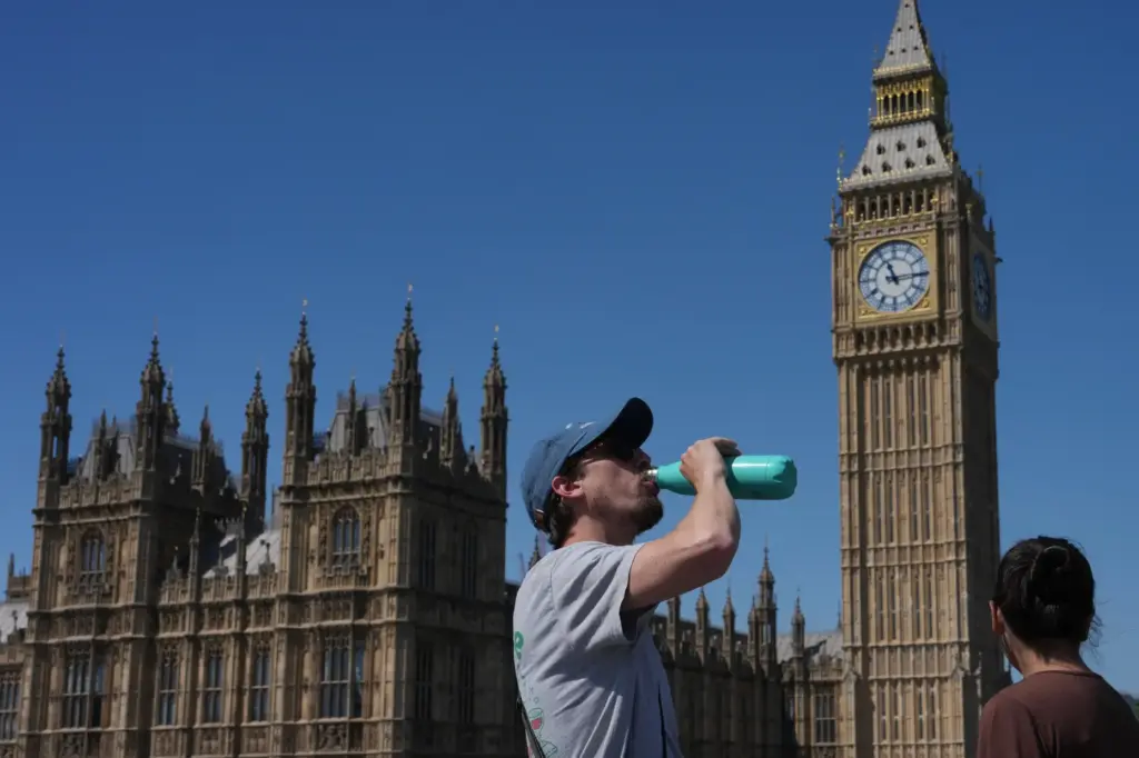 A man drinks outside the Palace of Westminster in London.