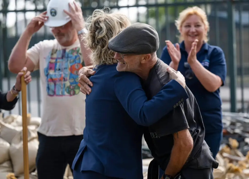 Brian Mank of Costa Mesa hugs Supervisor Katrina Foley after...