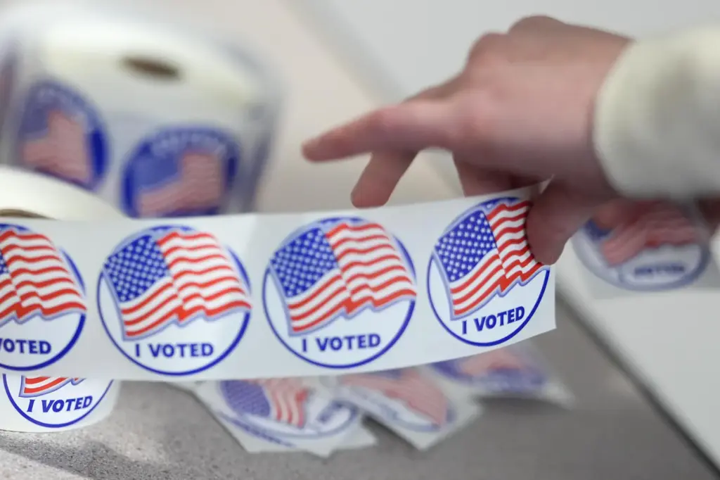 An election worker tears off 