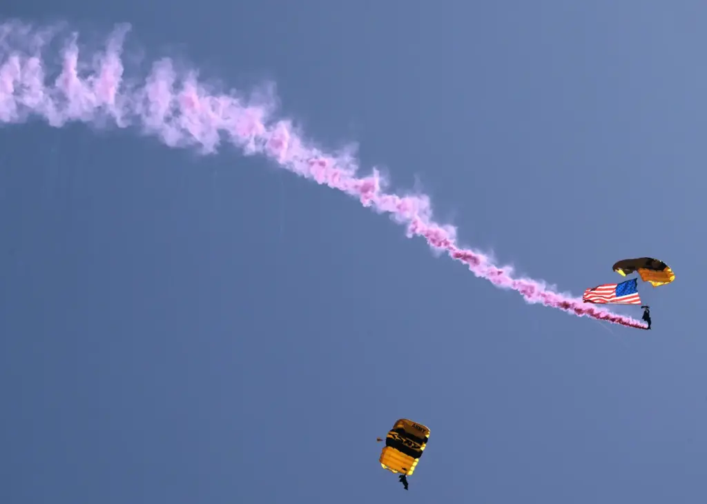 United States Army paratroopers desend with the American Flag during...