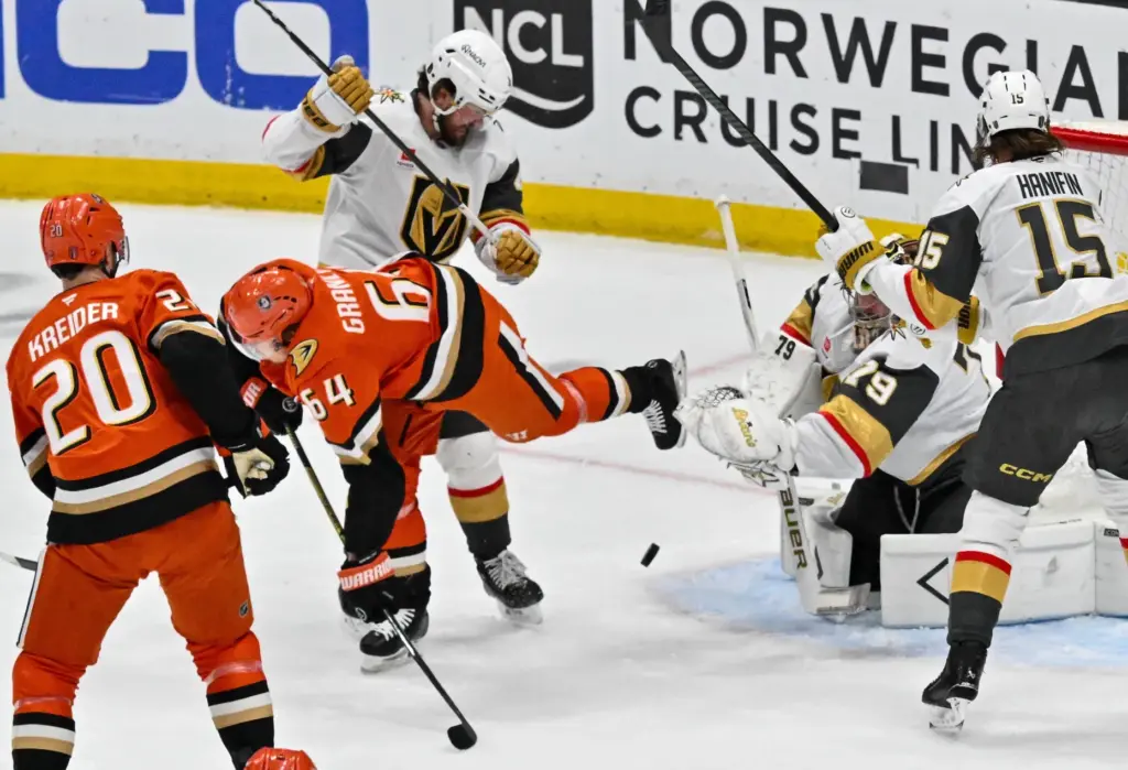 The Ducksâ Mikael Granlund (64) is tripped up during the...