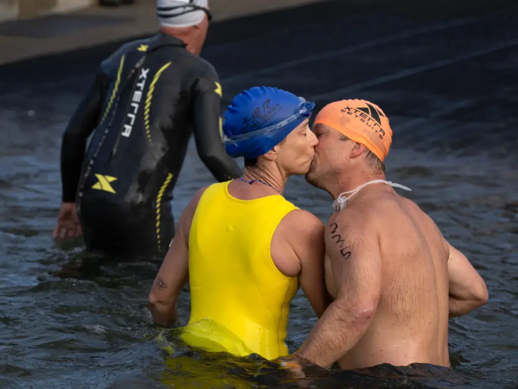 Two swimmers end their swim with a kiss during the...