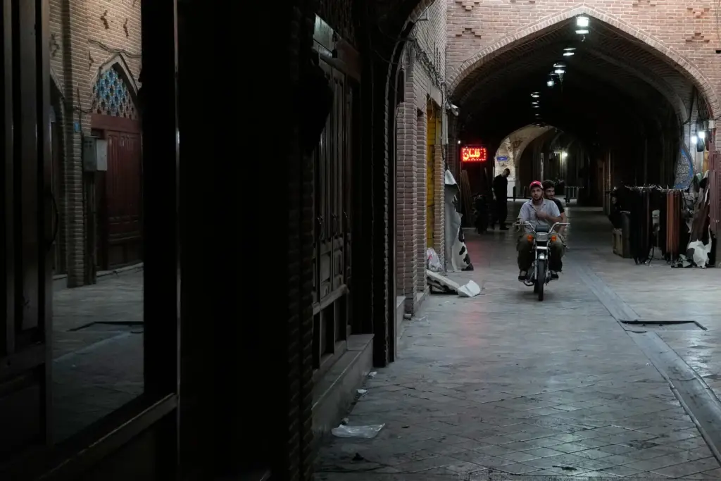 Men ride on their motorbike at the historic neighborhood of Oudlajan in Tehran, Iran.