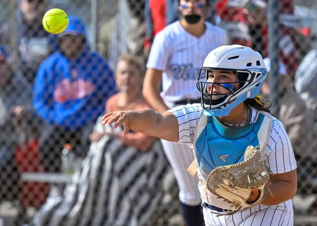 Marina catcher Gabriella DiBenedetto throws to third base with a...