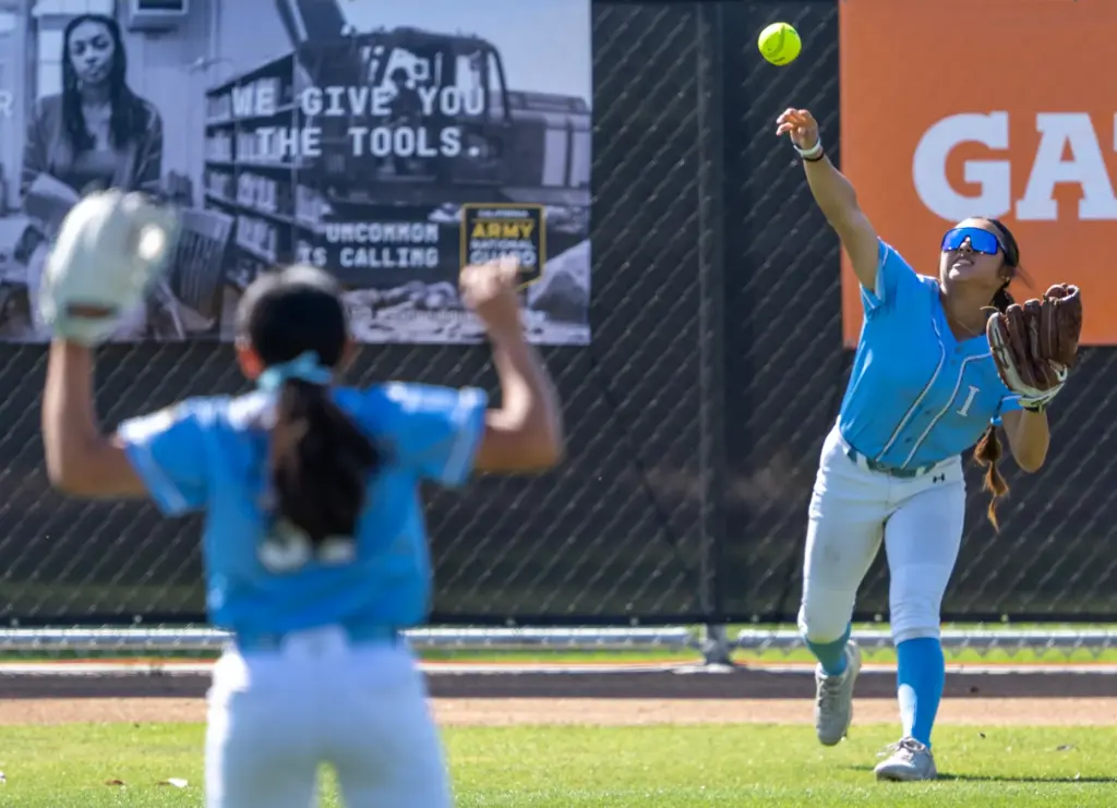 Irvine left fielder Eva Cho throws to shortstop Katie Liu...