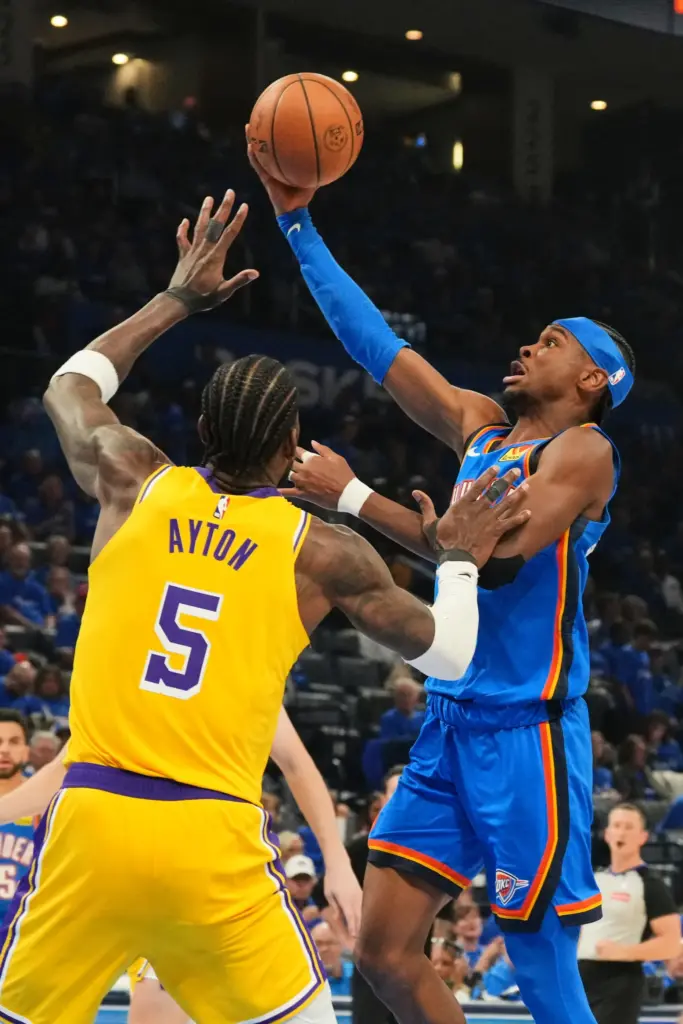 Oklahoma City Thunder guard Shai Gilgeous-Alexander, right, shoots as Lakers...