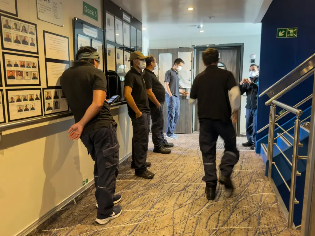 Crew members of the hantavirus-stricken cruise ship, MV Hondius, wait...