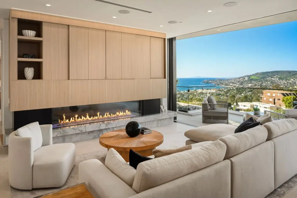 A long linear fireplace anchors the living room. (Courtesy of...