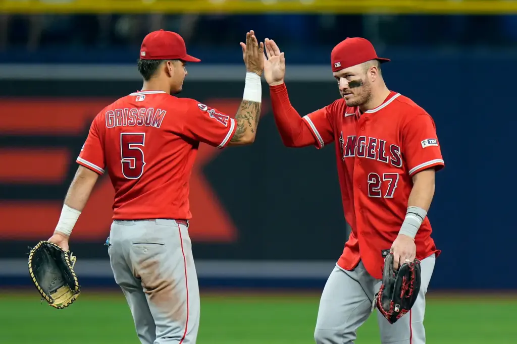 Angels’ Mike Trout (27) celebrates with Vaughn Grissom (5) after...