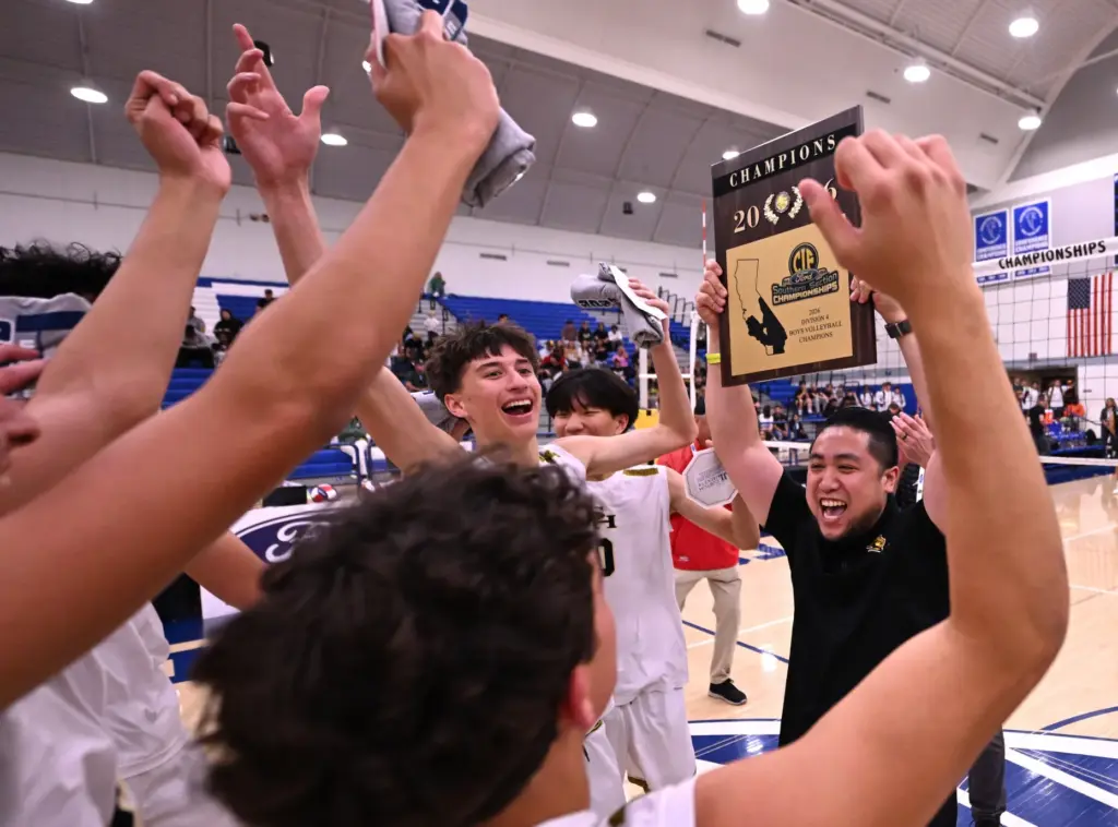 Head coach Albert Soliguen of the Sunny Hills Lancers hoists...