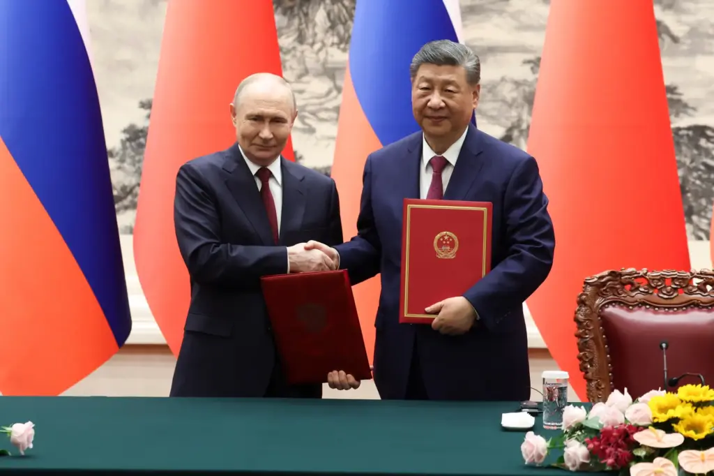Russian President Vladimir Putin and Chinese President Xi Jinping shake hands.
