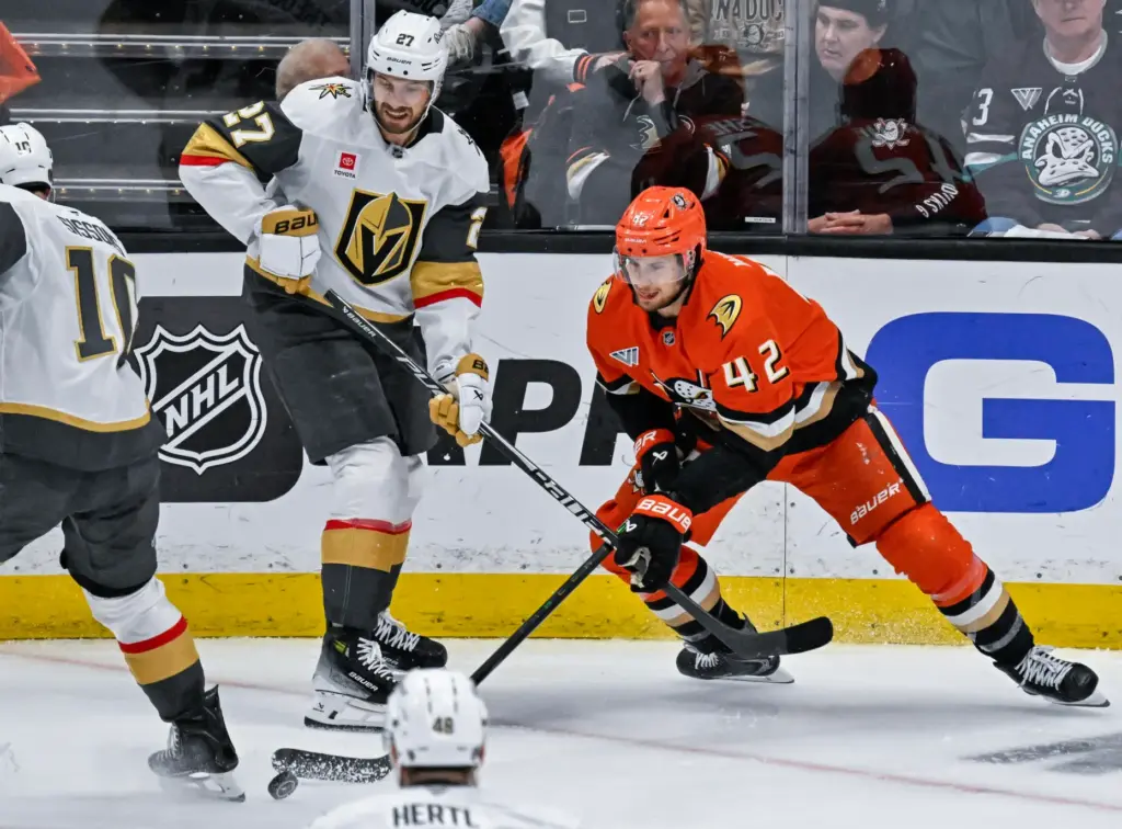 The Ducksâ Tim Washe, right, controls the puck while protecting...