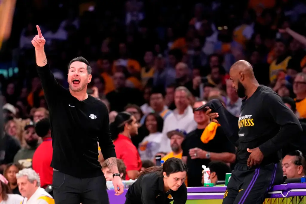 Lakers head coach JJ Redick, left, gestures from the sideline...