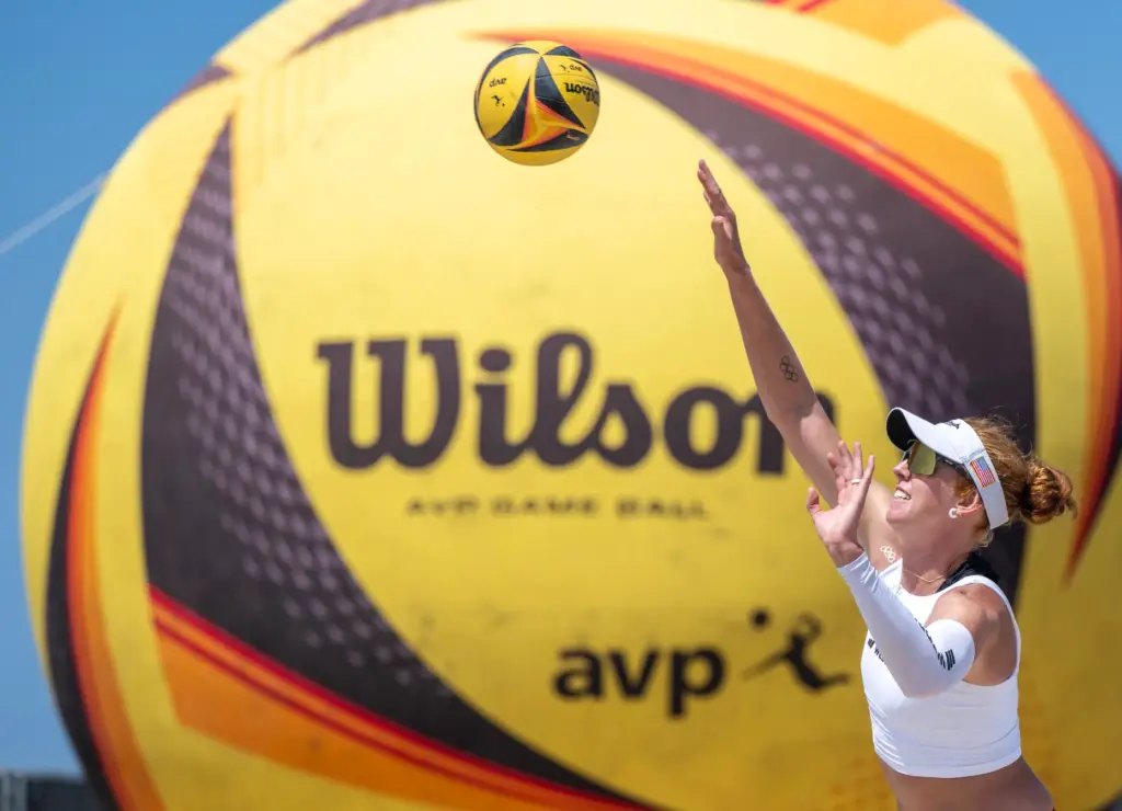 Kelly Cheng serves the ball while playing with her teammate,...