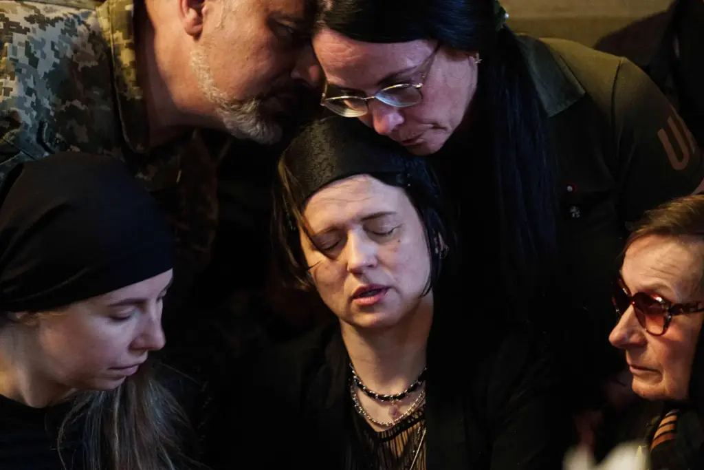 Tetiana Yakovlieva mourns by the coffins of her daughters Liubava and Vira Yakovlieva.