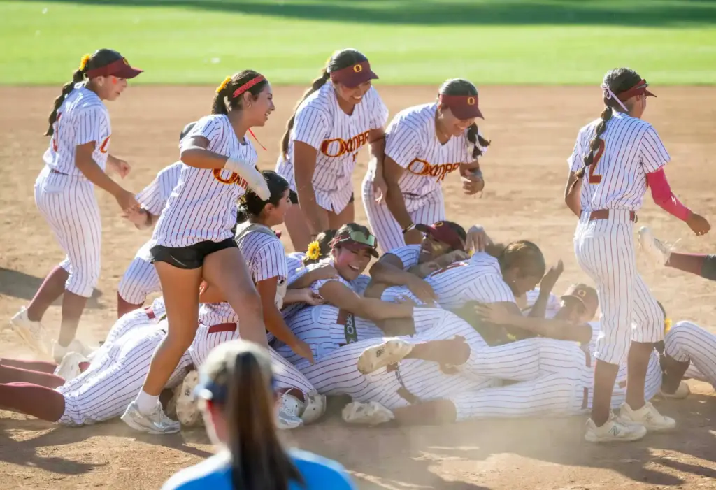 Oxnard players create a dogpile as they celebrate their 3-1...