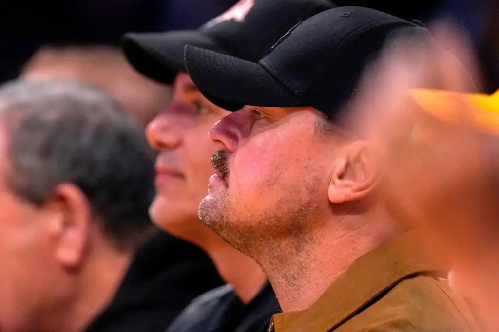 Actor Leonardo DiCaprio watches from a courtside seat during the...