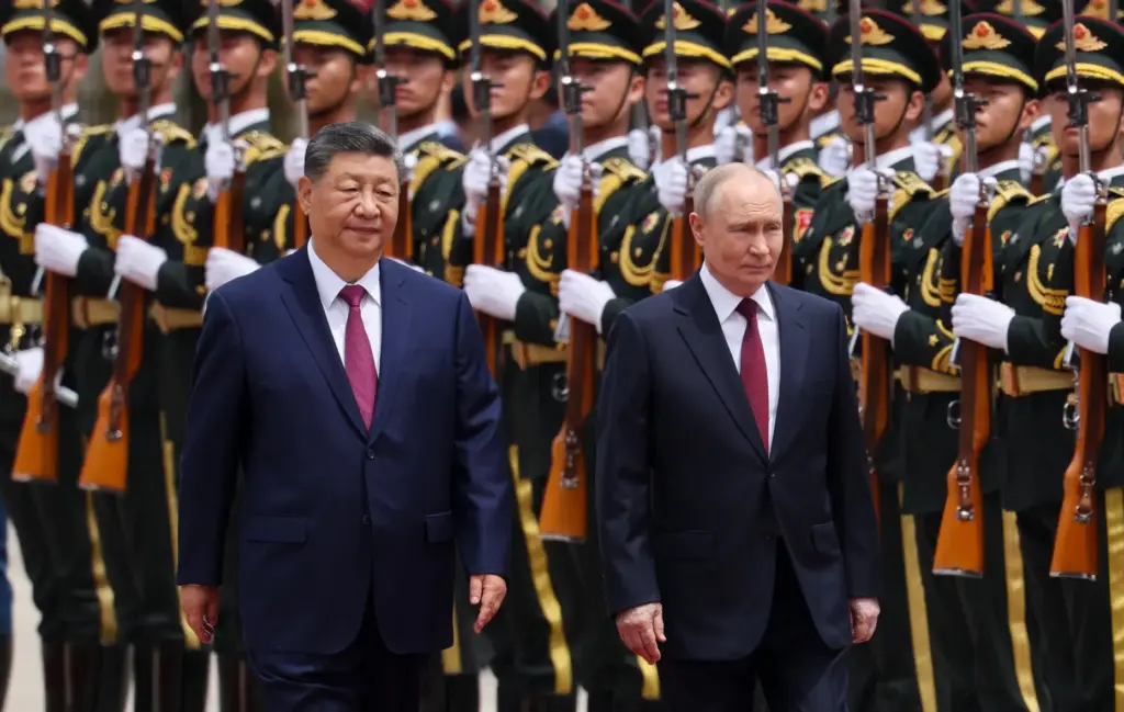 Russian President Vladimir Putin and Chinese President Xi Jinping inspect an honor guard.