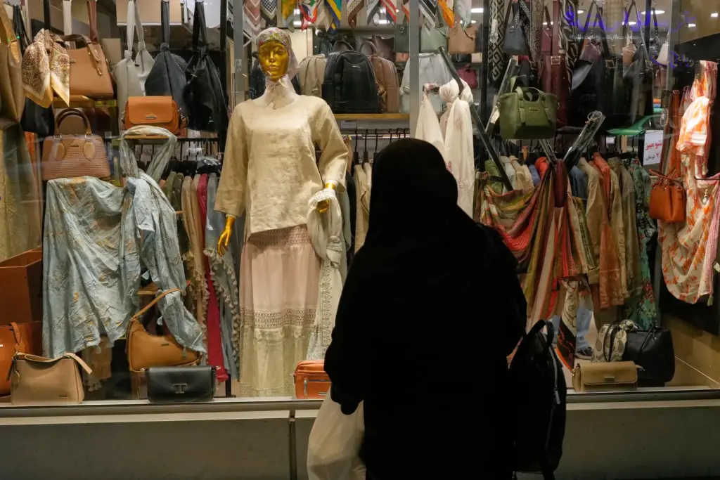 A woman looks at the window display a women’s clothing...