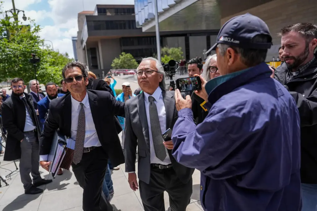 Kenneth Iwamasa, center, one of five people who pleaded guilty...