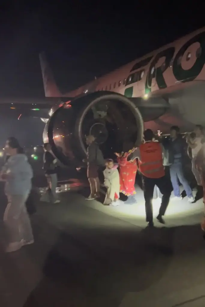 This image provided by Jack Estenssoro, passengers evacuate a airplane...