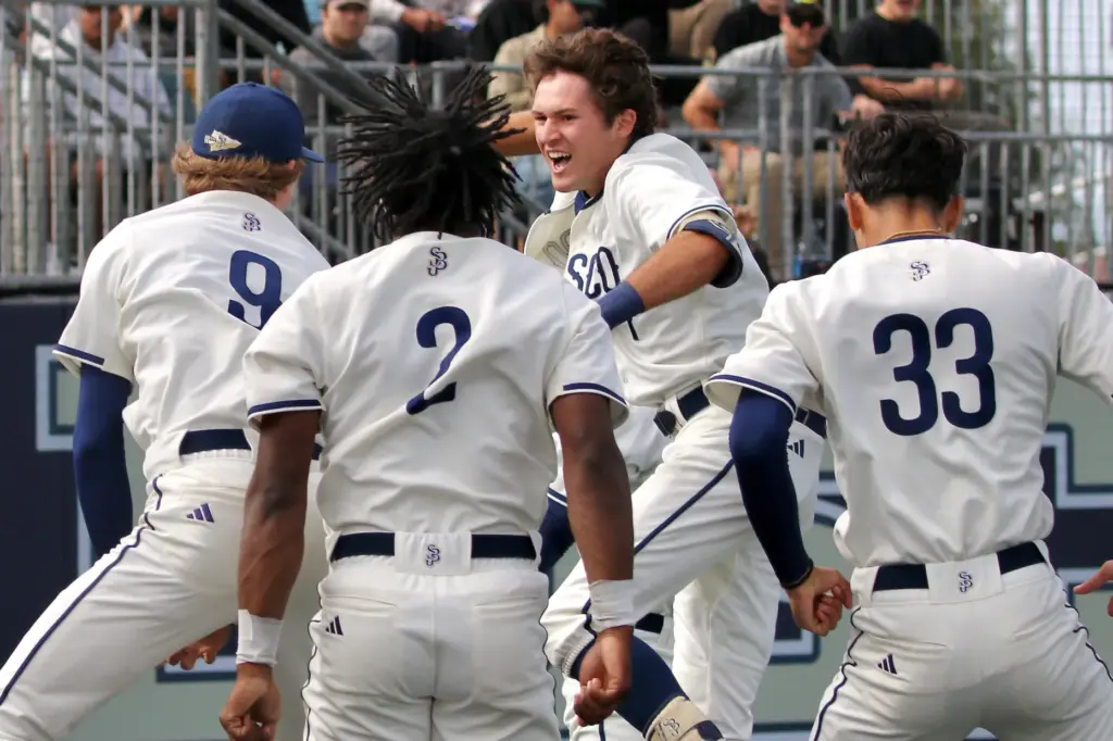 St. John Bosco senior Jack Champlin is greeted by teammates...