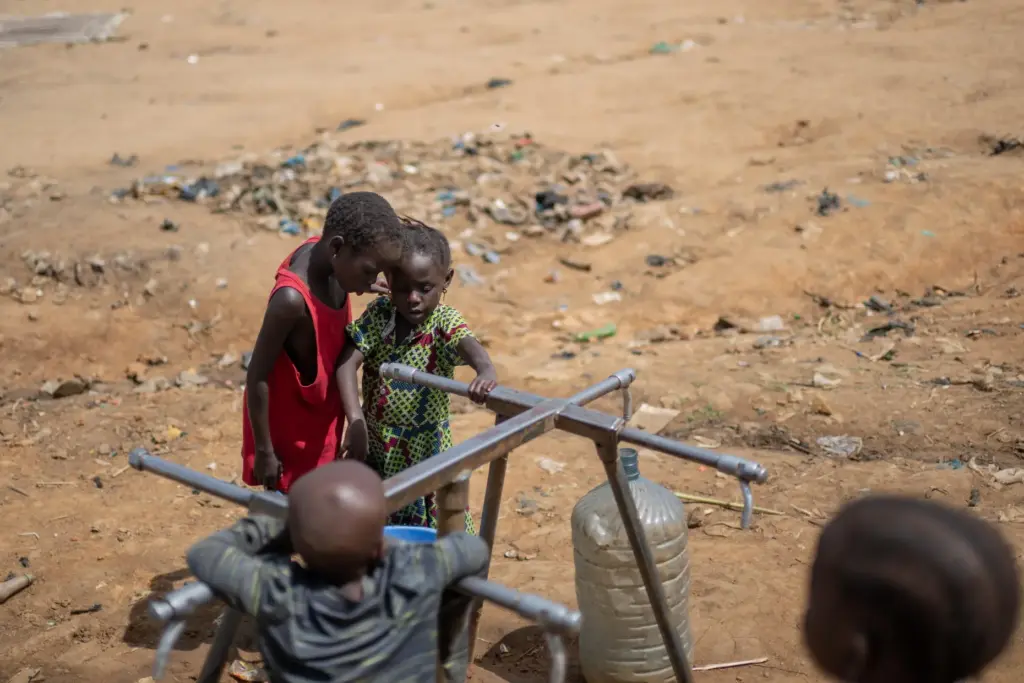 Internally displaced children play with a broken water pump at the camp.