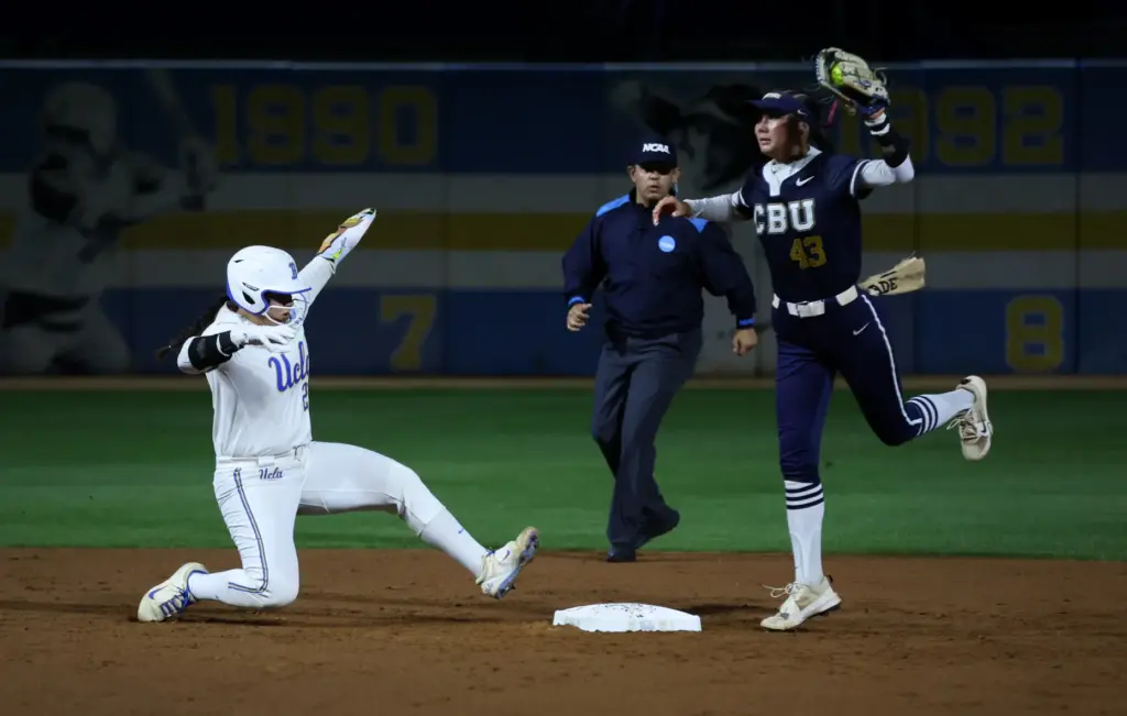 UCLAâs Alexis Ramirez, left, leaps back toward second base to...