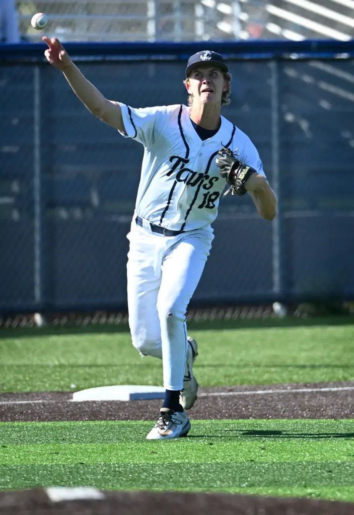 Third baseman Henry Mann (18) of Newport Harbor throws to...