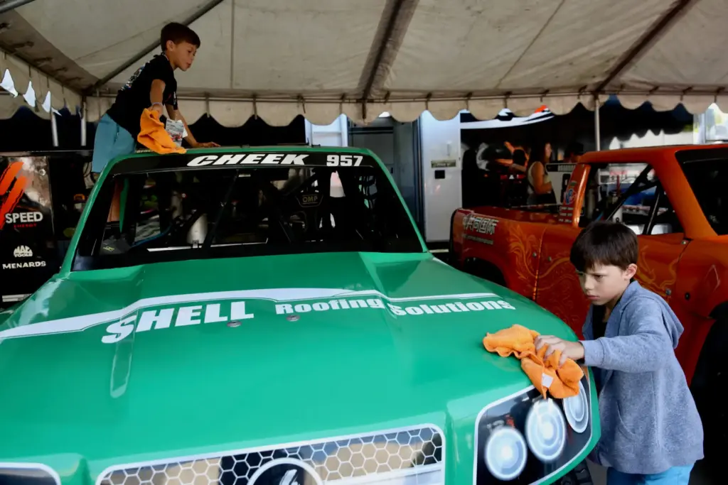 Young crew members spiff up a Stadium Super Truck in...