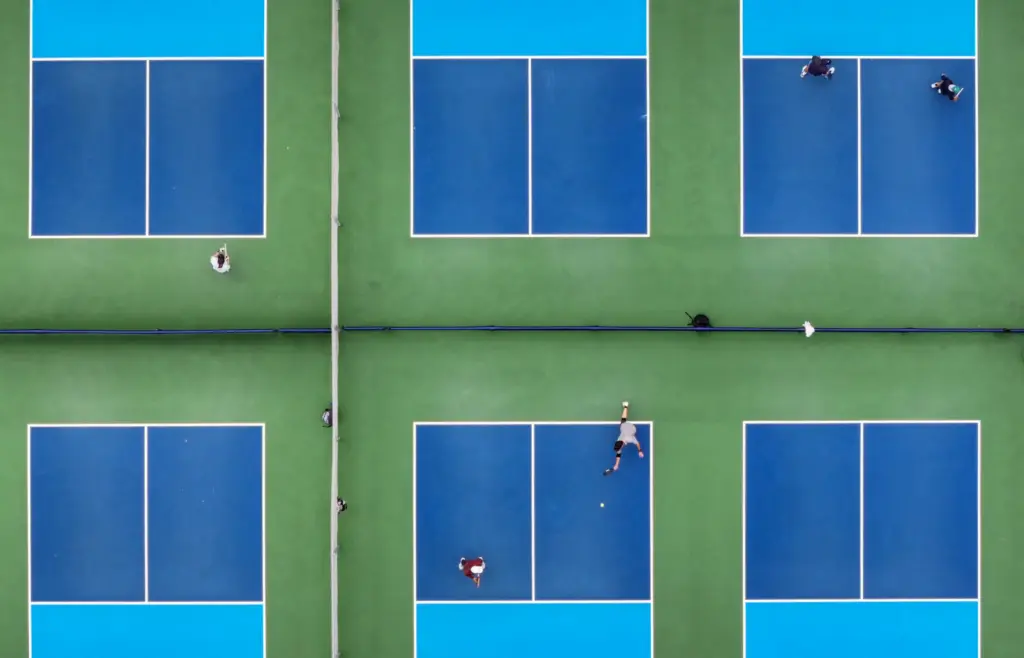 Pickleball players on new courts along side previously converted courts...