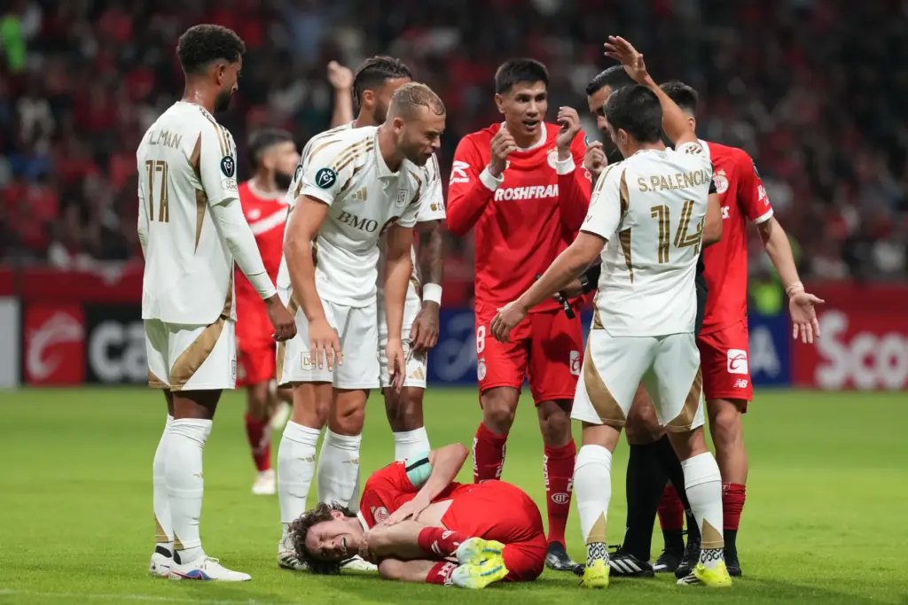 Toluca FC’s Marcel Ruiz, bottom, grimaces in pain after being...