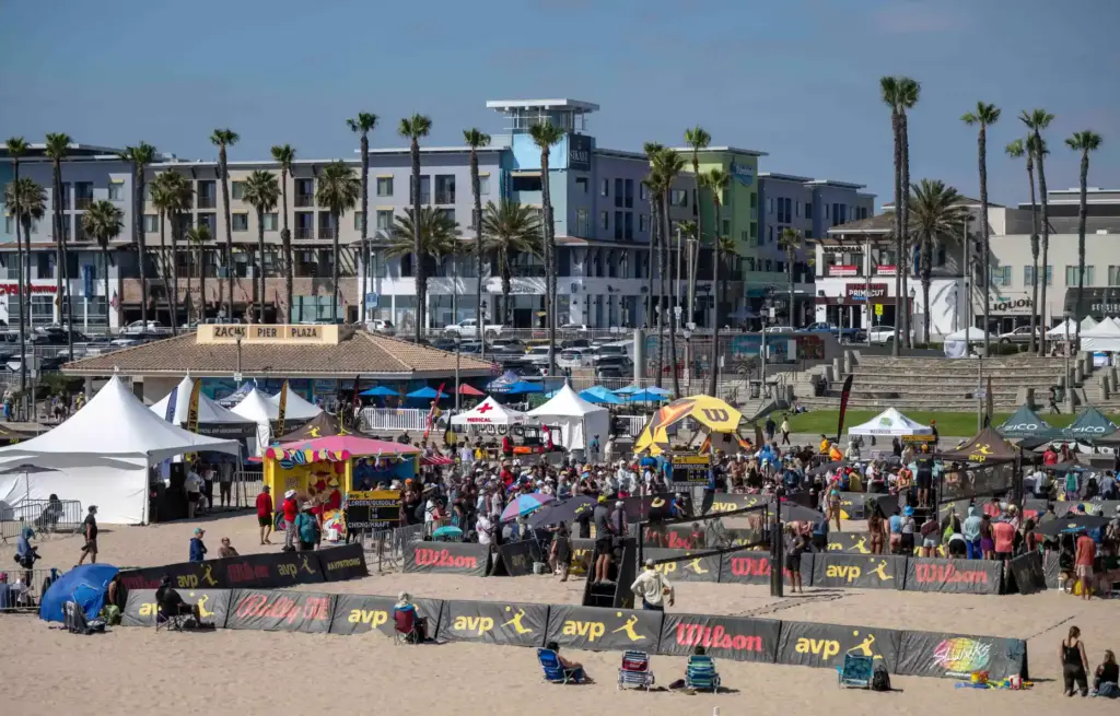 Fans line the sand around volleyball courts north of the...