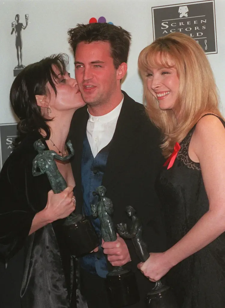 “Friends” cast member Courteney Cox, left, gives Matthew Perry a...
