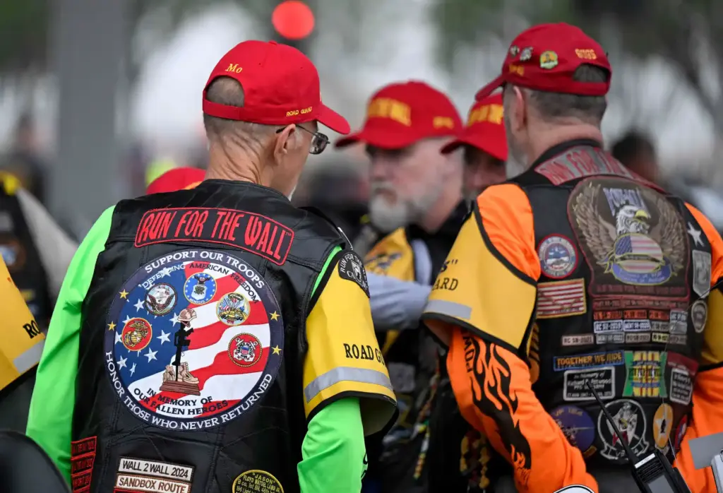 Riders gather near their motorcycles as they prepare to take...