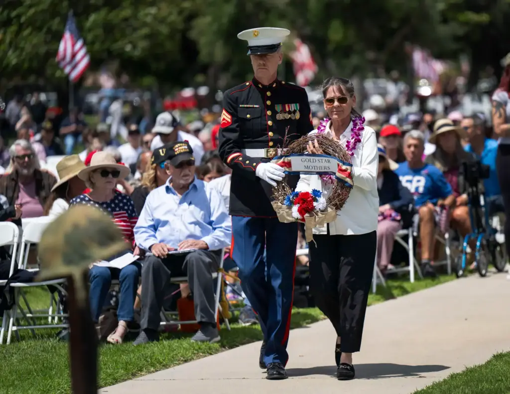 Gold Star mother Maria Simpson is accompanied by Marine Corps...