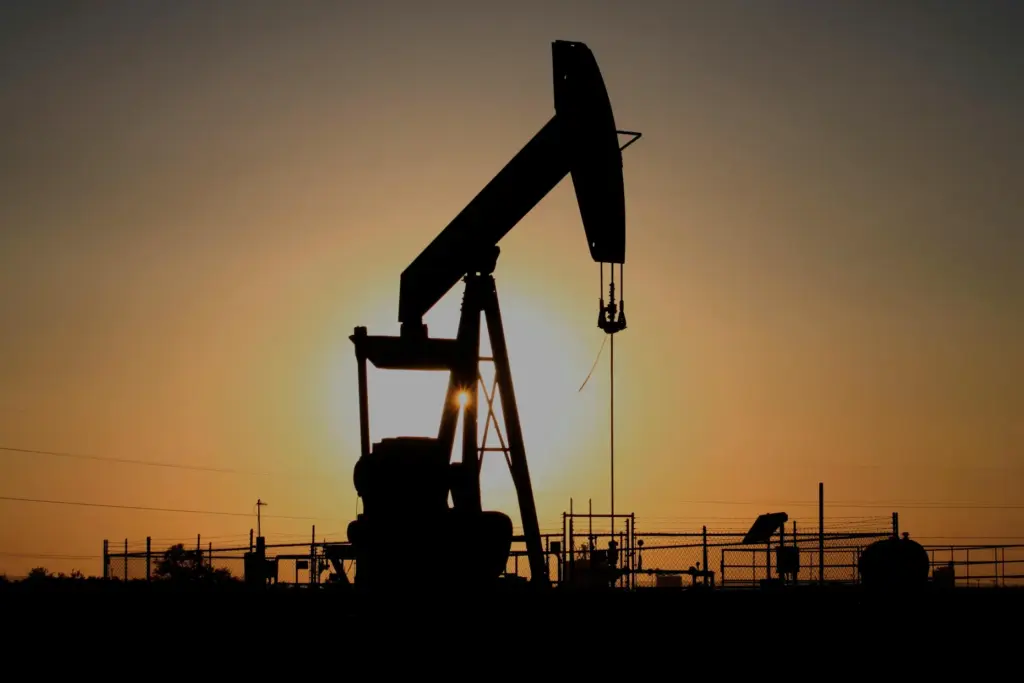 FILE – A pump jack operates at sunset in the...