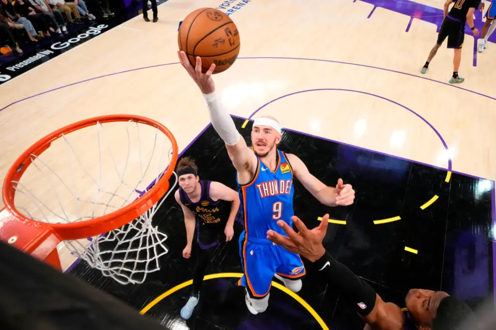 Oklahoma City Thunder guard Alex Caruso, center, shoots as Lakers...