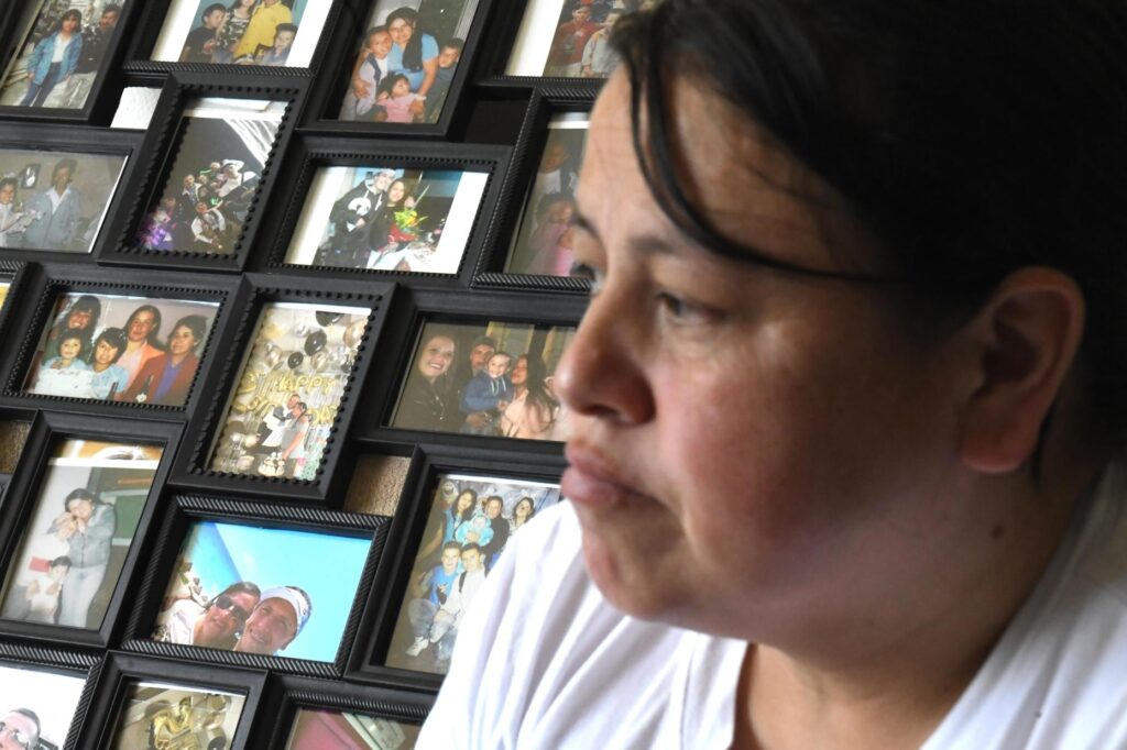 Adriana Garzon, mother of Brayan Rayo Garzon, sits in front of family photos.