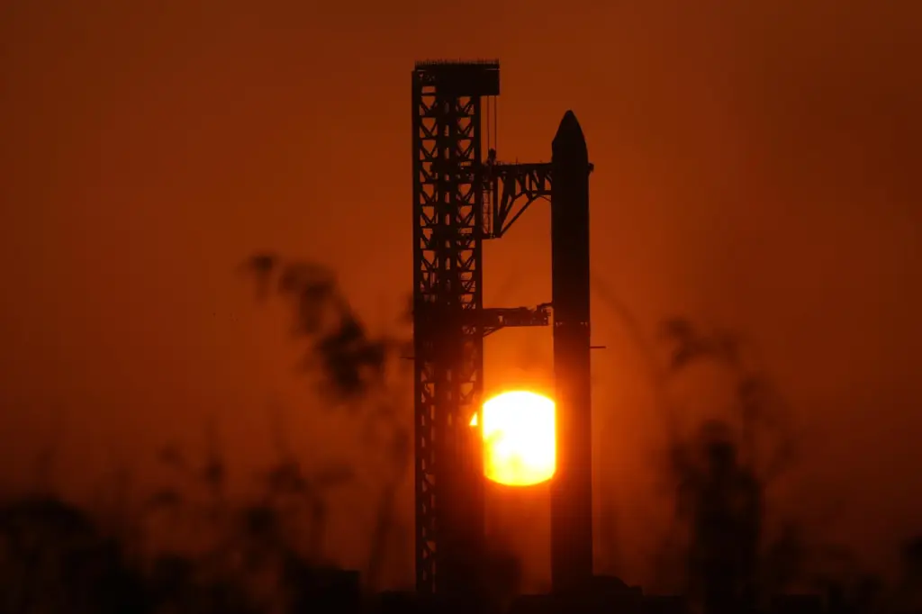 The sun rises behind SpaceX’s mega rocket Starship as it...