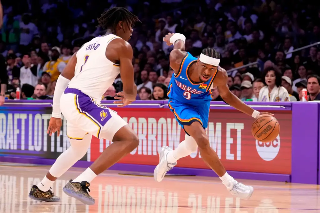Oklahoma City Thunder guard Shai Gilgeous-Alexander, right, drives as Lakers...